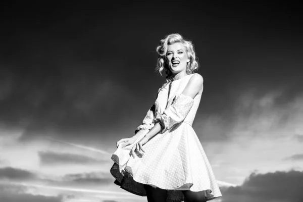 Woman in monroe dress on dramatic sky. Beautiful young woman in fashion dress outdoor. Sexy and sensual female model. — Stockfoto