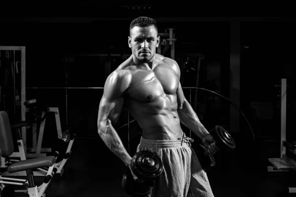 Esercizio in palestra. Allenamento sportivo. Fitness uomo concentrato sul sollevamento di un manubrio. — Foto Stock