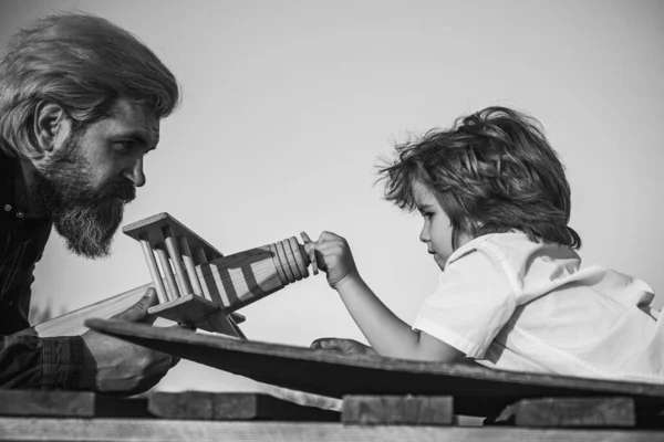 Ojciec i syn - szczęśliwy moment. Ojciec i chłopiec bawiący się samolotem zabawki. Marzenie o byciu pilotem. — Zdjęcie stockowe