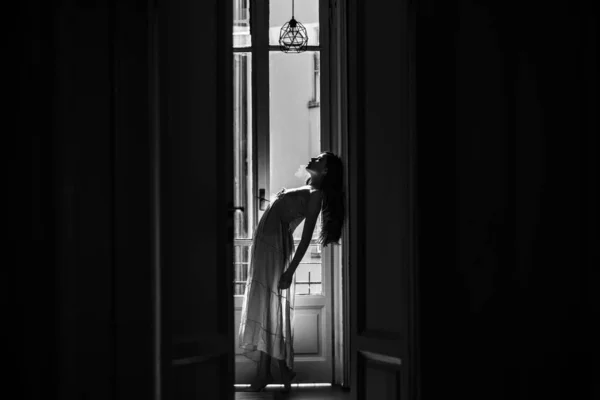 Mulher encontra manhã perto da varanda. Ela dança feliz. A rapariga está vestida de roupa de noite. Jovem mulher de pé perto da varanda. Relaxamento e conforto momento de folga . — Fotografia de Stock