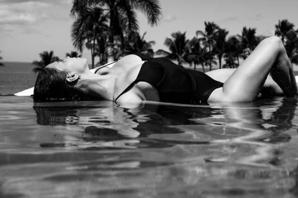 Hermosa mujer joven relajarse en la piscina en el complejo hotelero casi mar playa océano. —  Fotos de Stock