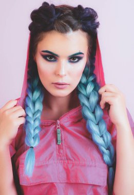 Renkli mor ombre saçlı ve profesyonel makyajlı güzel bir kadın pembe arka planda izole edilmiş. Kuaför salonu konsepti. Saçına renkli kanekalon örülmüş güzel bir kız..