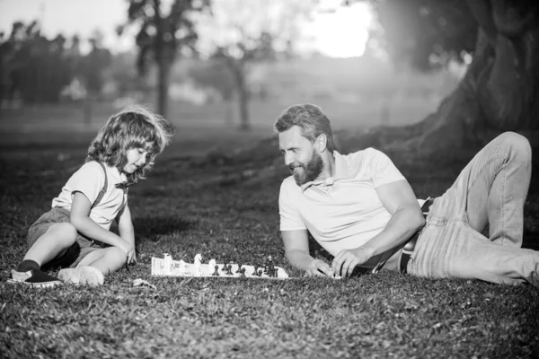 O pai joga xadrez com o filho. Família fora do jogo. Jovem espancando um homem no xadrez. — Fotografia de Stock