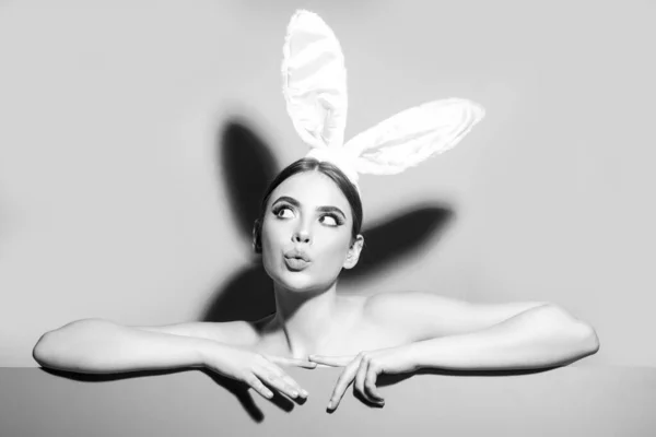 Estudio de mujer joven de Pascua con orejas de conejo. curioso aislado en rosa. —  Fotos de Stock