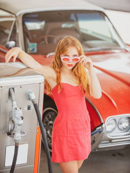 Σέξι Ρέτρο Γκερλ με αμάξι. Βενζινάδικο, γυναίκα ανεφοδιάζει το αυτοκίνητο. Κόκκινο ρετρό αυτοκίνητο. — Φωτογραφία Αρχείου