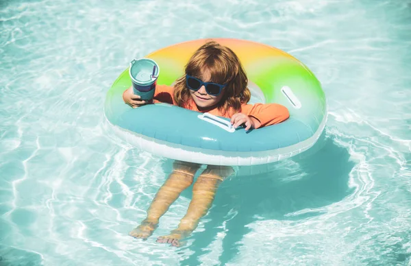 Šťastné dítě hrající si s plaveckým kroužkem v bazénu. Letní prázdniny. Zdravý dětský životní styl. — Stock fotografie