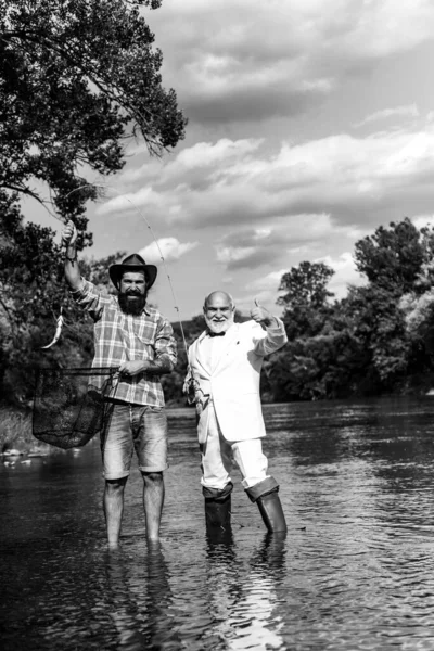 Portrait de joyeux deux hommes barbus pêche. Hobby pour l'âme. Pêche à la retraite. Amis pêche. Pêche à la mouche réussie. Maison de passe-temps. Joyeux pêcheur mature dans une rivière en plein air . — Photo