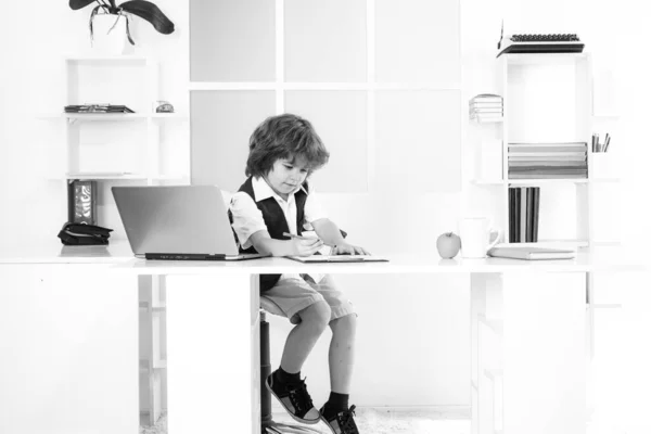 Μικρό παιδί επιχειρηματίας αγόρι χρησιμοποιώντας υπολογιστή κοιτάζοντας την οθόνη που εργάζονται στο διαδίκτυο κάθονται στο γραφείο. — Φωτογραφία Αρχείου