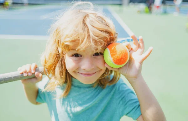 Kid tenisista na korcie tenisowym z rakietą i piłkami. — Zdjęcie stockowe