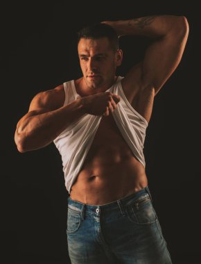 Kaslı adam karın kaslarını gösteriyor. Altı paket. Erkek striptiz. Çıplak gövde. Yakışıklı adam poz veriyor. Sportif, sağlıklı, güçlü kaslı adam. Üstsüz model..