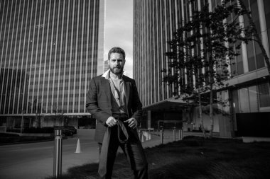 Moda kıyafetli modern seksi iş adamı şehir manzaralı dışarıda duruyor..