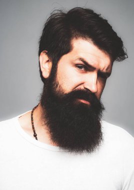 Kendine güvenen ciddi bir adamın portresi sakalı ve bıyığı var, ciddi ve izole görünüyor. Stüdyodaki hippi adam modelleri. İş adamı kendini ifade ederek düşünür. Yakışıklı erkek model, yakın çekim yüzü..