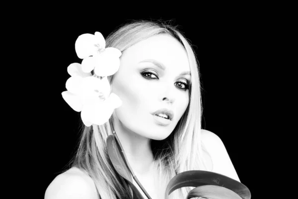 Salute di bellezza. Donna con fiore di orchidea. Prodotti cosmetici. — Foto Stock