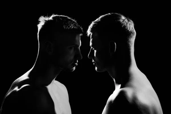Silhueta de dois homens de pé um ao outro em perfil, conceito de conflito, rivalidade e gritando. — Fotografia de Stock