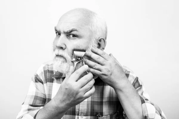 Az öreg szürke medve hajvágóval. Borbélyportré régi borotvapengéről, borbélyüzletről, borotválkozásról. Öreg szakállas ember. Szüreti borbélyüzlet. — Stock Fotó