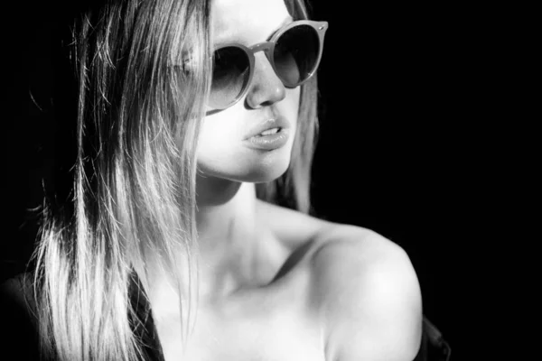 Güneş gözlüklü güzel bir kadının portresi çekici ve şehvetli görünüyor. Siyaha izole edilmiş dramatik stüdyo ışığı olan güzel bir yüz.. — Stok fotoğraf