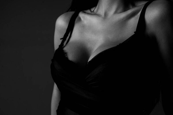 Women with sexy breas, boobs in bra, sensual tits. Beautiful slim female body. Lingerie model. Closeup of sexy female boob in black bra