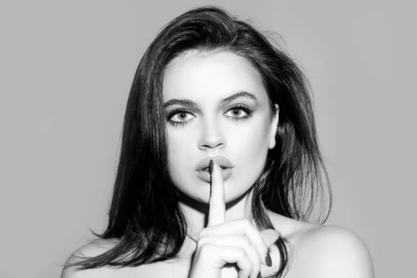 Vrouw gezicht, vinger op haar lippen. Stilte gebaar. Portret van sensueel jong vrouwelijk model. — Stockfoto