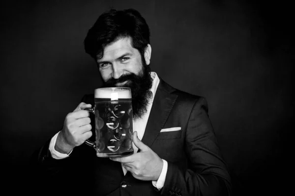 Das Konzept des Oktoberfests. Mann im schwarzen Anzug trinkt Bier. Pils und dunkles Bier. — Stockfoto