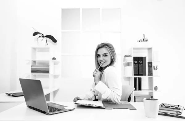 Umsichtige Geschäftsfrau, die Idee für ein Start-up notiert, Managerin, die mit einer App auf einem Netbook im Bürointerieur Einkommensrechnungen erstellt. Schönheitsunternehmerin. — Stockfoto