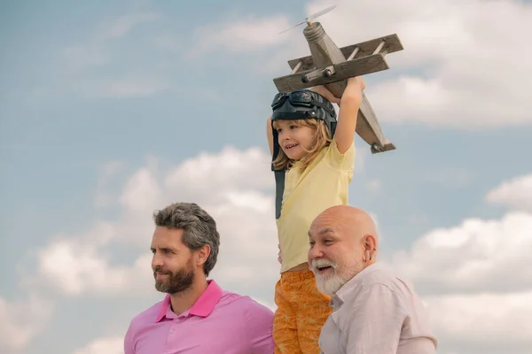 Dědeček otec a syn si hrají s letadýlkem venku na obloze. Šťastná rodina. Tři generace mužů. Šťastné dětství. Rodinný muž různého věku o víkendu. — Stock fotografie