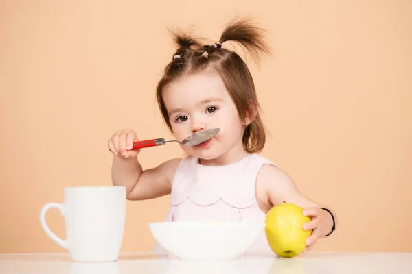 Schattig babyvoedsel, baby 's die eten. Kind eet gezond voedsel met een lepel in de studio, geïsoleerd. Grappige kinderen gezicht. — Stockfoto