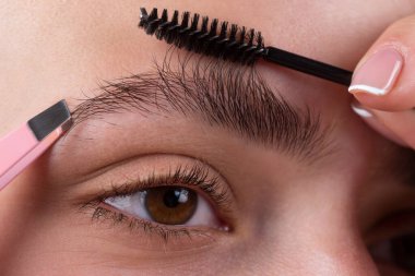 Kaş makyajı. Makro, kaşlarını kapat. Alnında kalem olan kaş şekillendiren güzellik mankeni. Doğal güzellik kaşları. Doğal makyajlı genç bir kız..