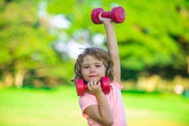 Kol halterli sportif çocuk. Fitness çocukları, sağlık ve enerji. Sağlıklı çocuk yaşam tarzı. Çocuk halterle egzersiz yapıyor. Sağlıklı aktiviteler, çocuk yaşam tarzı. Küçük çocuklar için spor.