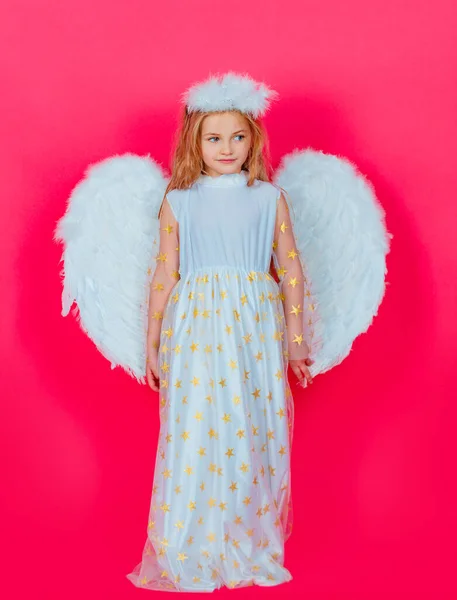 白い翼を持つ天使の子供の女の子。天使的な性格の子供。天使の衣装の白いドレスと羽の翼を着て幼児の女の子。罪のない子供の概念. — ストック写真