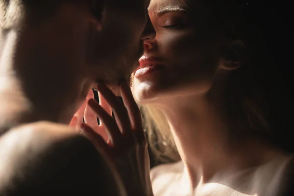 Lábios de mulher sensuais na paixão terna. Casal romântico apaixonado olhando um para o outro, abraçando e beijando no fundo preto. — Fotografia de Stock