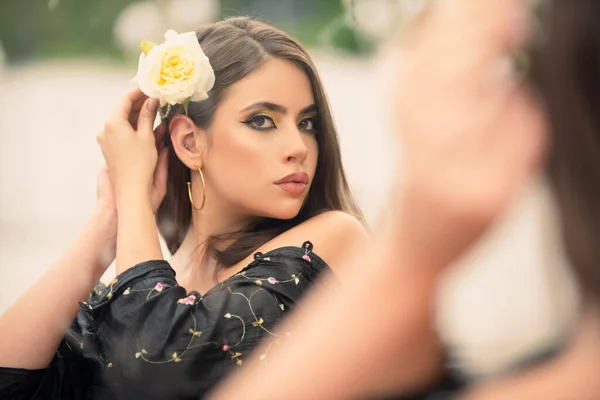 Módní žena s květinou ve vlasech. Krásná mladá žena v módních šatech venku. Sexy a smyslná modelka. Italský dívčí styl. — Stock fotografie