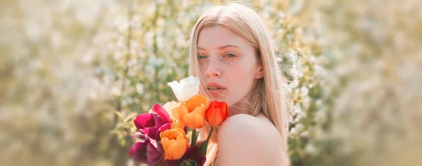 Cara de mulher de primavera para banner. Menina sensual com tulipa Flovers. Loira girll relaxante no jardim de flores. 8 marchar dia das mulheres. Beleza jovem desfrutando da natureza no jardim da primavera. — Fotografia de Stock