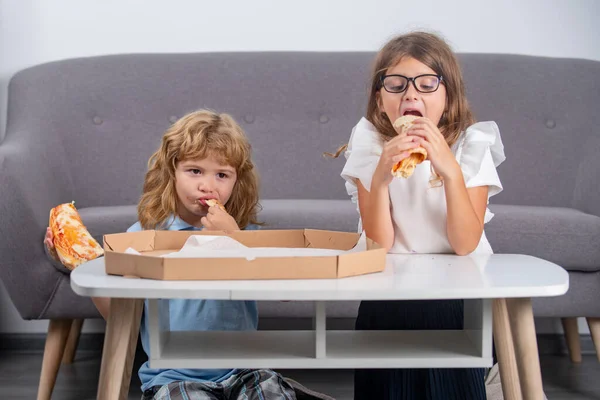 Pizza yiyen aç çocuklar. Komik şirin çocuklar, kız ve oğlan lezzetli pizzalar yiyor.. — Stok fotoğraf