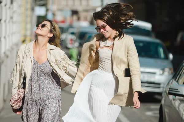 Chicas guapas corriendo en la calle al aire libre y divirtiéndose. Mejores novias riendo en ciudad urbana. —  Fotos de Stock