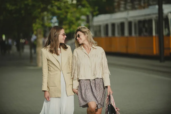 두 명의 여자가 선글라스를 끼고 도시를 걷고 있어. 재밌는 휴가, 낭만적 인 여행. 도시 생활 방식. — 스톡 사진