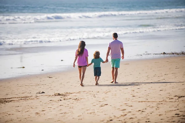 Libertà concetto di persone spensierate. Famiglia felice sulla spiaggia di Miami. Persone che si divertono durante le vacanze estive. Padre, madre e figlio sul mare blu. I genitori con bambino si rilassano all'aperto. Vacanze estive famiglia. — Foto Stock