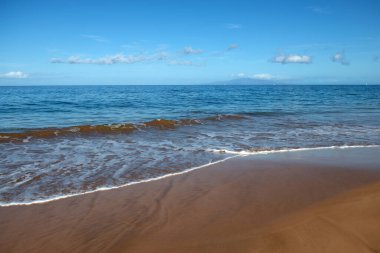 Altın kumu olan sahil, turkuaz okyanus suyu. Panoramik deniz manzarası. Yaz tatili için doğal arka plan.