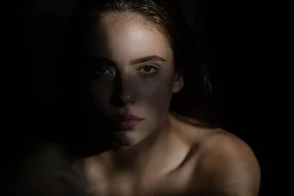 Cara de chica en la sombra. Mujer joven posando en el estudio sobre fondo negro. Luz y sombra. Retrato de moda de mujer hermosa con luz oscura en la cara. —  Fotos de Stock