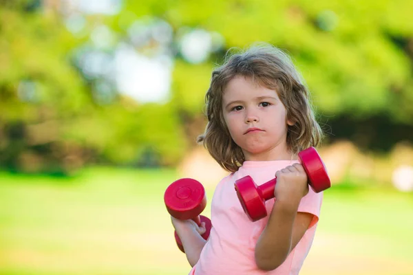 Hantle fitness dziecko ćwiczenia na świeżym powietrzu. Chłopiec wysportowany z hantlami. Sport portret dzieci. — Zdjęcie stockowe