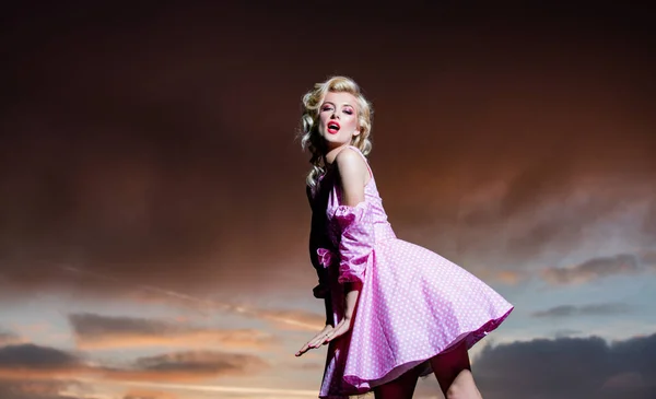 Женщина в платье Монро на драматическом небе. Красивая молодая женщина в модной весенней одежде. Портрет модели в модном платье. — стоковое фото