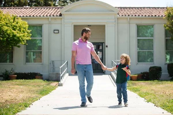 Father and son run with father after come back from school. School, family, education and outdoor concept. Back to school. — Stock Photo, Image