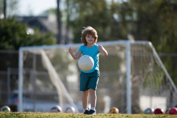 Niño pateando fútbol en el campo de deportes durante el partido de fútbol. Juegos de pelota activa. —  Fotos de Stock