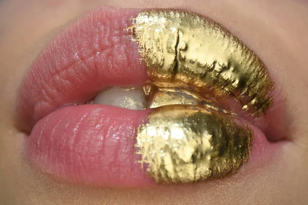 Sexy girl golden lips, gold mouth. Glowing gold skin make-up. Glitter metallic shine golden lipgloss makeup. Golden art design.