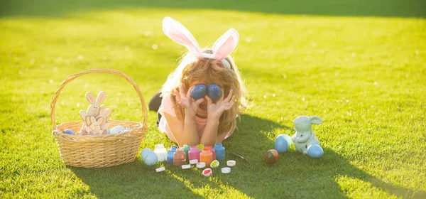 Velikonoční zajíčci. Dítě chlapec v zajíček velikonoční kryt oči s vejci. — Stock fotografie
