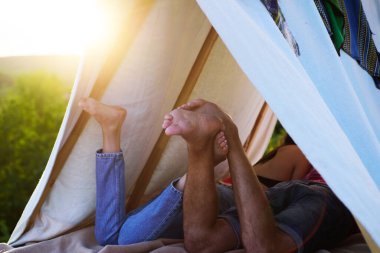 Yürüyüşçüler doğa üzerinde kamp yapar. Tatil kampında romantik aşıklar. Çadırdaki çiftin arka bacak görüntüsü. En iyi arkadaşım. Ayaklara odaklan..