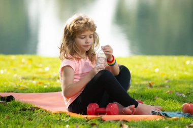 Çocuklar parkta spor yaptıktan sonra spor minderinde rahatlar..