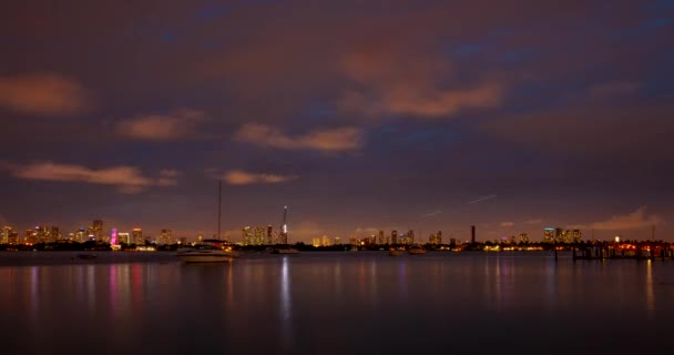 Miami panorama waktu selang. Waktu matahari terbenam di langit kota dan awan bergerak dengan pantulan riak air. MacArthur pusat kota, Causeway kota. — Stok Video