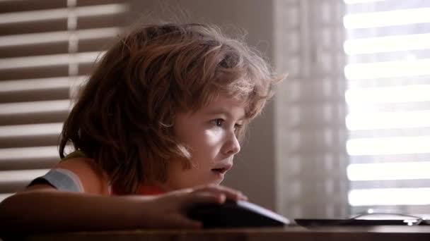 Detailní portrét atraktivního veselého chlapce s notebookem. Geniální dětské programování. — Stock video