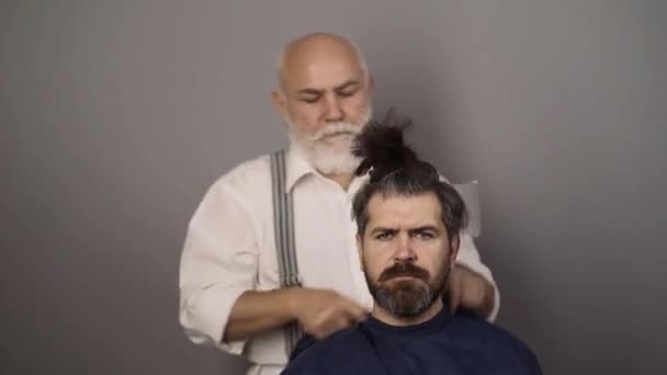 Zabawny fryzjer. Fryzjer stosujący kolorowy odcień na modelach włosów człowieka. Koncepcja sklepu reklamowego i fryzjerskiego. — Wideo stockowe