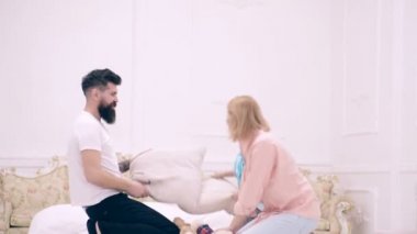 Mutlu aile yatak odasında yastık savaşı yapıyor. Baba ve çocuk birbirleri ile yastıklarla, mutlu çocuk ve ebeveynlerle oynuyorlar. Mutlu aile yatak odasında oynuyor..